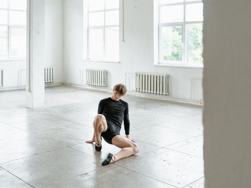 Spacious, minimalist studio with natural light, ready for an exercise session.